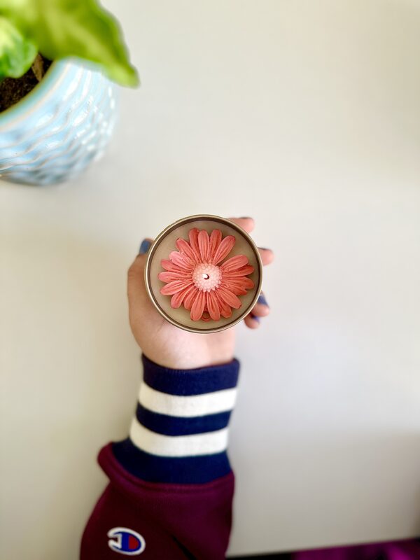 Hand-poured floral soy candle gift with white daisy wax toppings in a travel-friendly tin.
