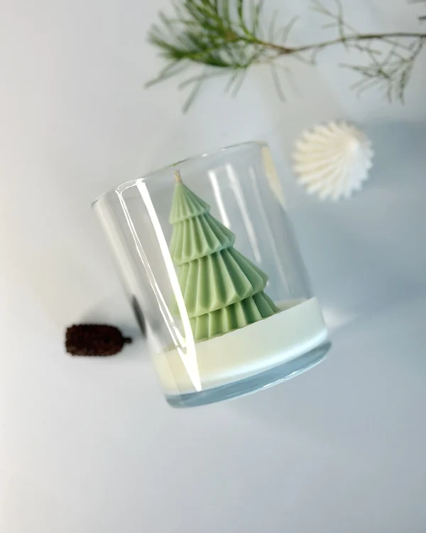 Nordic pine christmas candle in glass jar, sculpted tree design with pine sprig and pinecone