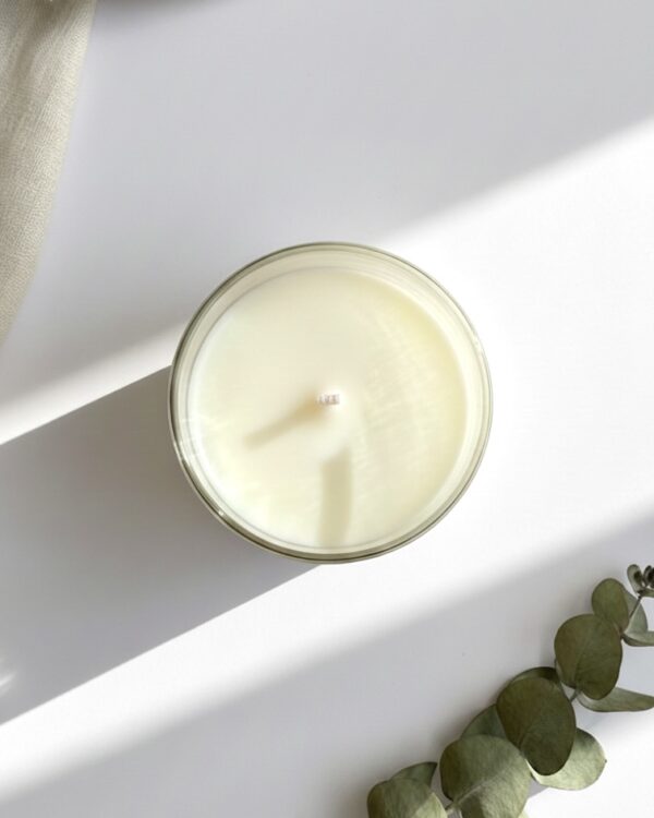 Detailed view of a clean-burning natural soy wax candle in a recyclable clear glass jar, ideal for sustainable relaxation gifts for her.