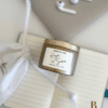 Cheers to Love personalised wedding candle bonbonniere in champagne tin with custom couple names label, resting on white cotton drawstring bag, Perth WA Krisha Essence