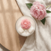 Hand-moulded 3D wax peony and white wax leaves on soy candle bowl surface