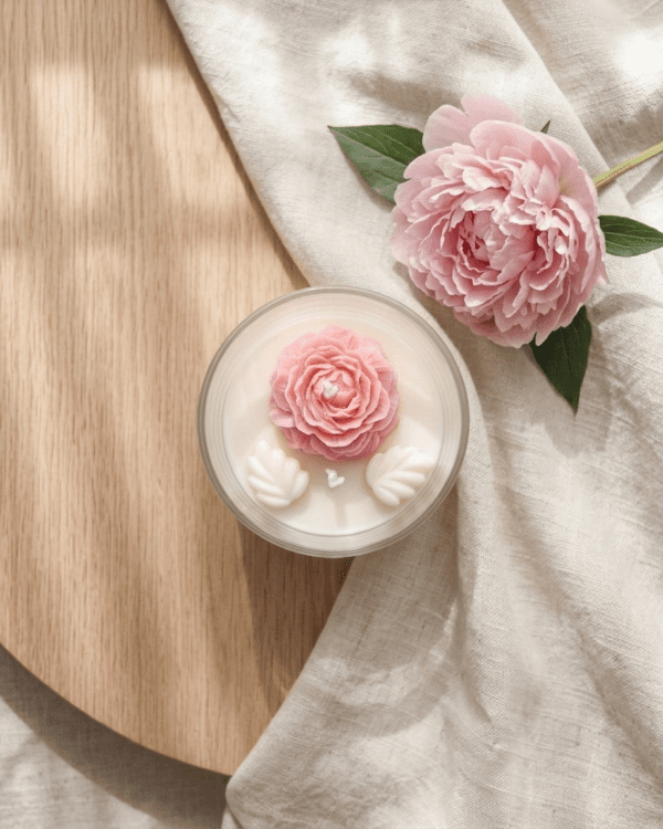 Hand-moulded 3D wax peony and white wax leaves on soy candle bowl surface