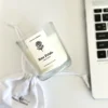 Overhead view of Krisha Essence Rose Petals minimalist glass jar candle and branded fabric gift bag, hand-poured in Perth using natural soy wax.