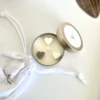 vanilla-latte-soy-candle-tin-overhead-krisha-essence-perth-wa Overhead view of vanilla latte soy candle in gold travel tin with ivory and mocha wax heart toppers, hand-poured in Perth WA by Krisha Essence